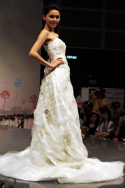 A model displays a wedding dress at the Hong Kong Convention and Exhibition Center in Hong Kong on June 6, 2010. The 59th Summer Wedding Service, Banquet and Beauty Expo is held here from June 4 to 6 presenting tens of thousands of wedding dress sorts from 18 countries and regions.