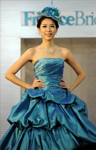 A model displays a wedding dress at the Hong Kong Convention and Exhibition Center in Hong Kong on June 6, 2010. The 59th Summer Wedding Service, Banquet and Beauty Expo is held here from June 4 to 6 presenting tens of thousands of wedding dress sorts from 18 countries and regions. 