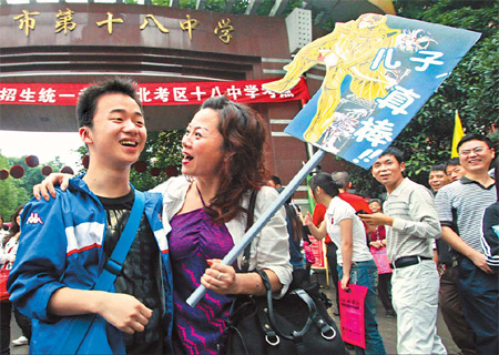  mother greets her son outside Chongqing No 18 Middle School after the morning session of the college entrance examination on Monday. The placard reads: 'Son, you are the best.' [China Daily]