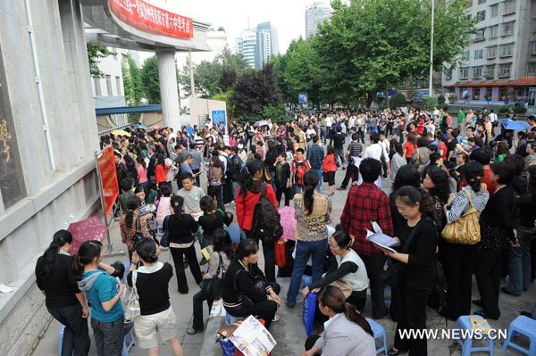 Parents whose children attend college entrance exam wait outside Guiyang No. 6 Middle School in Guiyang, capital of southwest China's Guizhou Province, June 8, 2010. About 9.57 million examinees in China attend this year's national college entrance exam. [Photo: Xinhua] 