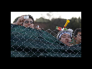 Soccer fans peek over the fence of the Portugal soccer team training camp in Magaliesburg June 6, 2010. [China Daily/Agencies]