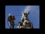 A worker cleans a statue paying homage to those who died in the Anglo-Boer War as Cape Town prepares for the 2010 World Cup soccer tournament April 29, 2010. [China Daily/Agencies]