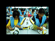 Workers on the production line stitch the official ball of 2010 South Africa World Cup  at Jiujiang Simaibo Sports Equipment Corporation Ltd. in Jiujiang, east China's Jiangxi province, May 7, 2010. [China Daily/Agencies]