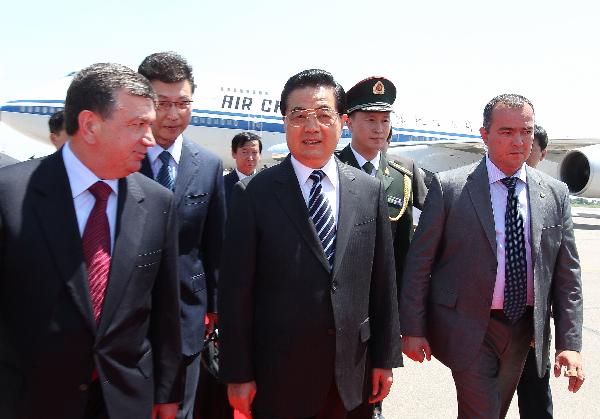 Chinese President Hu Jintao (C Front) is welcomed by Uzbekistan's Prime Minister Shavkat Mirziyaev (L) upon his arrival in Tashkent, capital of Uzbekistan, June 9, 2010. President Hu arrived here on Wednesday for a state visit to Uzbekistan, where he will also attend a summit of the Shanghai Cooperation Organization. [Ju Peng/Xinhua]