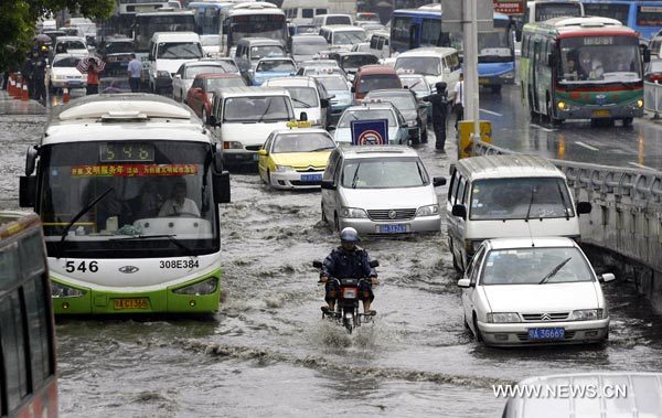 Vehicles wade through a waterlogged street in Wuhan, capital of central China's Hubei Province, June 8, 2010. Heavy rainstorm hit Wuhan from June 7, causing severe waterlogging in some downfold. [Xinhua]