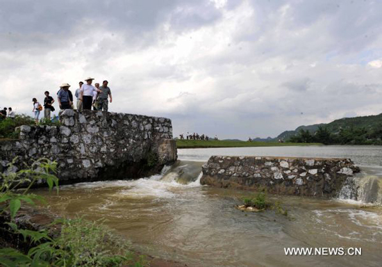 An excavator works on Lingkou Reservoir to discharge floods in Laibin City, southwest China's Guangxi Zhuang Autonomous Region, on June 8, 2010. 