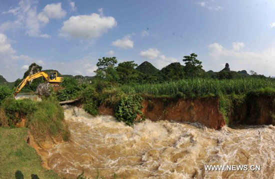 An excavator works on Lingkou Reservoir to discharge floods in Laibin City, southwest China's Guangxi Zhuang Autonomous Region, on June 8, 2010. 