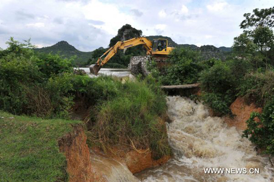 An excavator works on Lingkou Reservoir to discharge floods in Laibin City, southwest China's Guangxi Zhuang Autonomous Region, on June 8, 2010. 