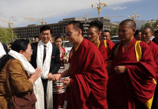 The 11th Panchen Lama (C) is welcomed by Professor Ceyang (L) of Tibet University in Lhasa, capital of southwest China's Tibet Autonomous Region, June 9, 2010. The 11th Panchen Lama visited Tibet University and Tibet College of Tibetan Medicine in Lhasa on Wednesday. (Xinhua