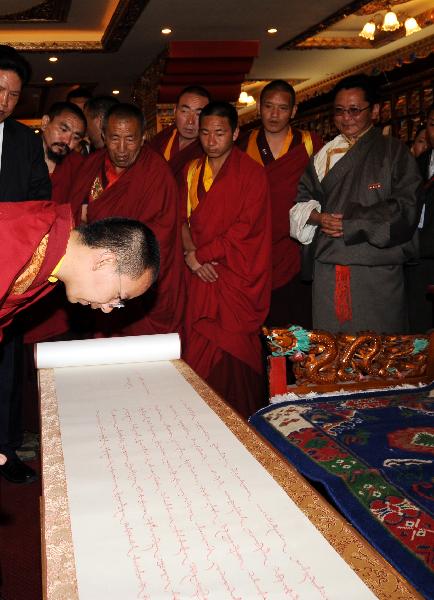 The 11th Panchen Lama (Front) looks at a calligraphy work of the Tibetan language in Lhasa, capital of southwest China's Tibet Autonomous Region, June 9, 2010. The 11th Panchen Lama visited Tibet University and Tibet College of Tibetan Medicine in Lhasa on Wednesday. (Xinhua/