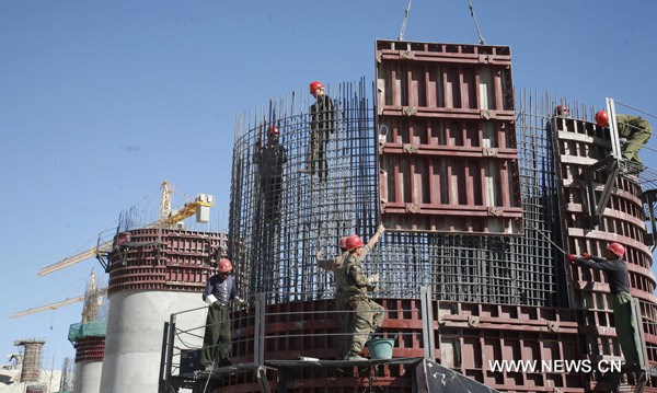 Rail workers proceed with the construction of the 3-km railway bridge in Nanhu town, the starting point of a railway over the Lop Nur, a former lake that is known as &apos;the sea of death&apos;, in Hami, northwest China&apos;s Xinjiang Uygur Autonomous Region, June 9, 2010. [Xinhua] 