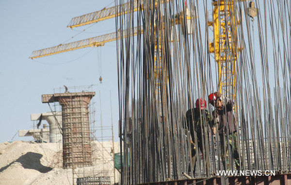 Workers colligate the reinforcing steel bars cluster at the construction site of the 3-km railway bridge in Nanhu town, the starting point of a railway over the Lop Nur, a former lake that is known as &apos;the sea of death&apos;, in Hami, northwest China&apos;s Xinjiang Uygur Autonomous Region, June 9, 2010. [Xinhua]