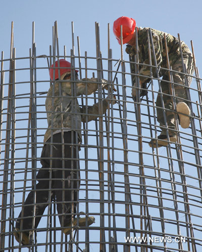 Two workers colligate the reinforcing steel bars cluster at the construction site of the 3-km railway bridge in Nanhu town, the starting point of a railway over the Lop Nur, a former lake that is known as &apos;the sea of death&apos;, in Hami, northwest China&apos;s Xinjiang Uygur Autonomous Region, June 9, 2010. [Xinhua]