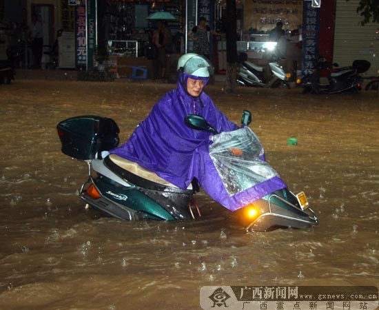A man drives his motorcycle in a waterlogging street in Wuzhou, Guangxi Zhuang Autonomous Region of south China. Heavy rainstorm hit Wuzhou on June 9, 2010, causing severe waterlogging in the area. [Chinanews.com.cn]
