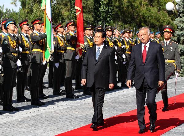 Chinese President Hu Jintao (L), accompanied by Uzbekistan&apos;s President Islam Karimov (R), inspects the guard of honor during the welcoming ceremony hosted by Karimov for him, in Tashkent June 9, 2010. [Xinhua photo]