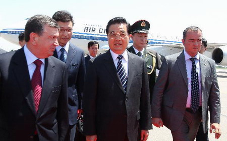 President Hu Jintao (C Front) is welcomed by Uzbekistan's Prime Minister Shavkat Mirziyaev (L) upon his arrival in Tashkent, capital of Uzbekistan, June 9, 2010. [Xinhua]