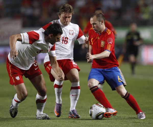 Spain's Andres Iniesta (R) fights for the ball with Poland's Dariusz Dudka (L) and Jakub Blaszczykowski during a friendly soccer match in Murcia June 8, 2010. (Xinhua/Reuters Photo)