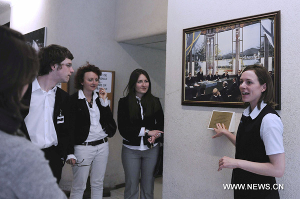 A tourist guide introduces artworks exhibited in the Palace of Nations in Geneva, Switzerland, June 9, 2010. The Palace of Nations in Geneva was built between 1929 and 1936 as the headquarters of the League of Nations. It has served as the home of the United Nations Office in Geneva since 1946, when the UN secretary general signed the Headquarters Agreement with the Swiss authorities, although Switzerland did not become a UN member until 2002. (Xinhua/Yu Yang)