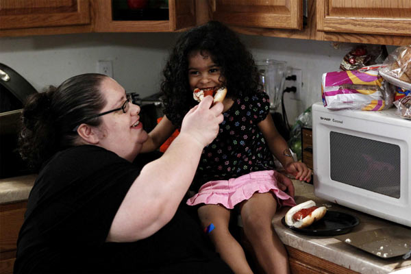 Donna Simpson feeds her daughter Jacqueline a hot dog in the kitchen of their home in Old Bridge, New Jersey June 8, 2010.[China Daily/Agencies]