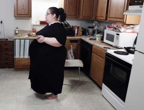 Donna Simpson walks to the kitchen table with her breakfast at her home in Old Bridge, New Jersey June 8, 2010. [China Daily/Agencies]