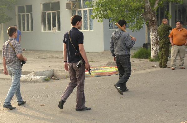 Armed men walk along a street in the city of Osh in southern Kyrgyzstan June 11, 2010. At least 12 people were killed and 126 were wounded during the violence in southern Kyrgyzstan on Friday, the Health Ministry said. [Xinhua] 