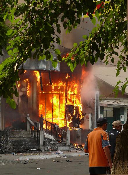 Men walk past a burning building in the city of Osh in southern Kyrgyzstan June 11, 2010. At least 12 people were killed and 126 were wounded during the violence in southern Kyrgyzstan on Friday, the Health Ministry said. [Xinhua]