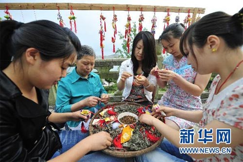 Women in Zigui make sachets with different aromatic spices to celebrate the Dragon Boat Festival on Thursday, June 10, 2010. This year's festival falls on June 16th. [Hao Tongqian/Xinhua] 