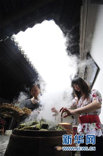 Two girls in Zigui pick out Zongzi from a steamer during their celebration of the Dragon Boat Festival on Thursday, June 10, 2010. The festival, falling on the fifth day of the fifth month of the Chinese lunar calendar, is for people to remember Qu Yuan, a patriotic poet more than 2,000 years ago. Zigui, a county in central China's Hubei province, is thought to be the poet's hometown. [Photo: Xinhua/Hao Tongqian] 