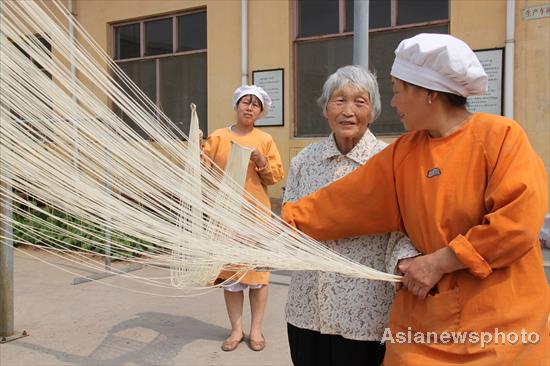 Pastry cooks air out hollow dry noodles in Yigou village, Tangyin county of Henan province, June 6, 2010. [Asianewsphoto] 