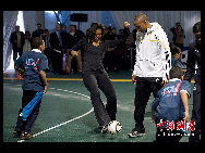 U.S. first lady Michelle Obama (L2) plays with several pupils in a youth soccer clinic on March 5, 2010 in Washington, DC.[chinanews.com] 