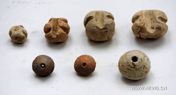 Photo taken on June 8, 2010 shows the spindle wheels and net weights made in ancient China&apos;s Han Dynasty (206 BC-220 AD) and excavated at Caoxie Village in Lianzhou Town of Hepu County, southwest China&apos;s Guangxi Zhuang Autonomous Region. [Xinhua]