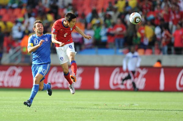 Kim Jung-Woo of South Korea (R) heads the ball with Giorgias Karagounis of Greece during their group B first round match at the 2010 FIFA World Cup at Nelson Mandela Bay stadium in Port Elizabeth, South Africa, on June 12, 2010. (Xinhua/Chen Haitong)