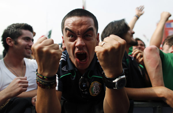 A man celebrates Mexico&apos;s goal as he watches the 2010 World Cup opening match between Mexico and South Africa on a large TV screen in Zocalo Square, downtown Mexico City June 11, 2010. (Xinhua/Reuters Photo)