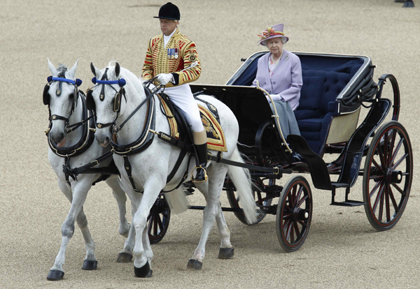 Britain&apos;s Queen Elizabeth rides in an open carriage as she attends the Trooping the Colour ceremony in London June 12, 2010. [Xinhua/Reuters]