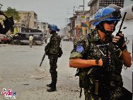 UN peacekeepers – the commonly known 'Blue helmets' – appear in a photo inside the UN Pavilion. UN peacekeepers wear uniformed blue helmets but carry their respective country's mark.[Photo by Pierre Chen] 