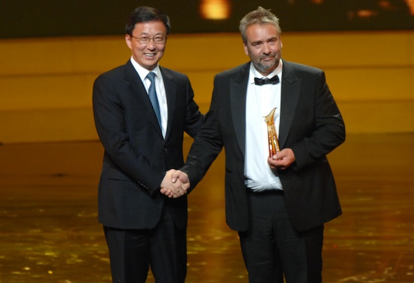 Han Zheng, mayor of Shanghai (left), shakes hands with French director Luc Besson after presenting him with the Outstanding Artistic Life Achievement Award at the opening ceremony of the 13th Shanghai International Film Festival at Shanghai Grand Theatre on June 12, 2010.