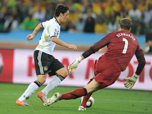 Mesut Ozil of Germany (left) tries to dribble past the goalkeeper of Australia during the 2010 World Cup Group D match at the Moses Mabhida Stadium on Sunday. [Xinhua]