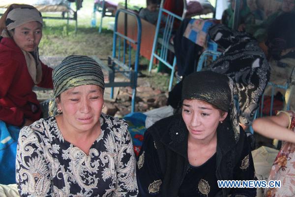 Kyrgyz refugees sit in Andizhan, on the Uzbek border region with Kyrgyzstan, June 14, 2010. The Uzbekistan authorities have already officially registered 45,000 refugees from the ethnic violence in neighbouring Kyrgyzstan as of Sunday morning, a deputy prime minister of Uzbekistan told journalists on Monday. Uzbekistan has ordered its border crossing with Kyrgyzistan closed, saying it can not receive more refugees. (Xinhua/Dong Longjiang) 