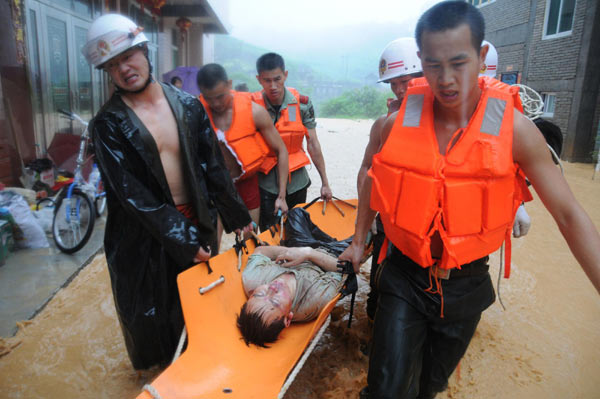 Rescuers carry a passenger injured in the flash floods in Nanping, Fujiang Province, June 14, 2010. [Photo / Xinhua]