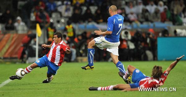 Carlos Bonet of Paraguay(L) clears the ball during a Group F first round match against Italy at 2010 FIFA World Cup at Green Point stadium in Cape Town, South Africa, on June 14, 2010.