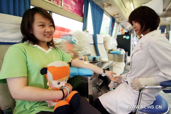 A student named Li Yule, who has finished this year's national college entrance exams, donates blood at the Quancheng Plaza in Jinan, capital of east China's Shandong Province, June 14, 2010, the 7th World Blood Donor Day.