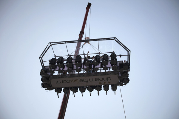 Guests have dinner at an event venue known as 'Dinner in the Sky' as they are seated around a table that is lifted by a crane in Beirut, June 11, 2010. The table is suspended at a height of 50m and accommodates 22 guests, who are secured by six-point harnesses. 