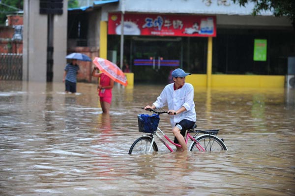 A man on a bicycle wades through the flooded street in Nanning, capital of Southwest China's Guangxi Zhuang autonomous region, June 15, 2010. A fresh spell of heavy rains has pounded Guangxi since June 14, triggering floods in some regions of Guangxi.[Photo/Xinhua] 