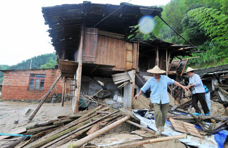 Residents seek for available living goods among the ruins of the houses destroyed by the flooding in Nanping, Fujian Province, June 15, 2010. Fujian provincial meteorology bureau has issued a red alert as the precipitation in some areas in Fujian is expected to reach 50-80 millimeters within 3 hours, or more rain is forecasted after the precipitation has exceeded 100 mm.[Photo/Xinhua]