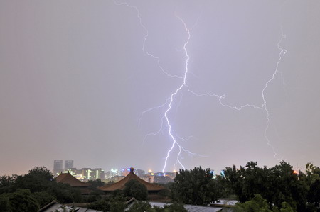  Lightning is seen across Beijing during the storms, which caused chaos during the morning commute on June 17, 2010. [China Daily]