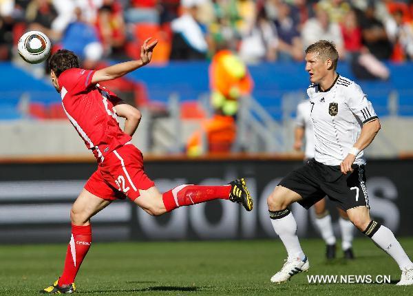 Serbia's Zdravko Kuzmanovic (L) heads the ball as Germany's Bastian Schweinsteiger watches him during the 2010 World Cup Group D soccer match between Germany and Serbia at the Nelson Mandela Bay stadium in Port Elizabeth, South Africa, on June 18, 2010. (Xinhua/Liao Yujie)