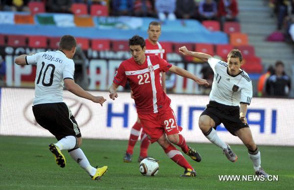 Serbia's Zdravko Kuzmanovic (C) drives the ball against Germany's Lukas Podolski (L) and Miroslav Klose during the 2010 World Cup Group D soccer match between Germany and Serbia at the Nelson Mandela Bay stadium in Port Elizabeth, South Africa, on June 18, 2010. (Xinhua/Yang Lei)