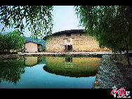 Photo taken on June. 6, 2010 shows the Dadi Tulou, earth buildings in Chinese, in Hua'an County, southeast China's Fujian Province. Built on a base of stone, the thick walls of Tulou were packed with dirt and fortified with wood or bamboo internally. The architectural arts of the Fujian Tulou can be traced back nearly 1,000 years, and their design incorporates the tradition of fengshui (favorable siting within the environment). [Photo by Zhou Yunjie]