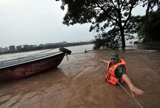 A rescuer works on a flooded street in Guilin, southwest China's Guangxi Zhuang Autonomous Region, June 17, 2010.