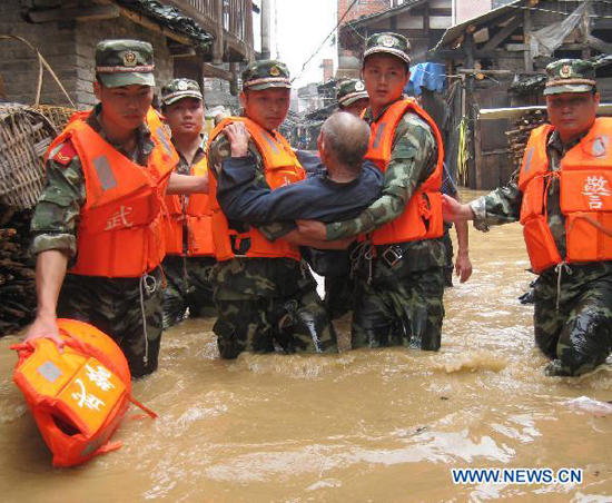 Soldiers transfer an old man trapped by the flood water at Songxi Town of Qingliu County, southeast China's Fujian Province, June 18, 2010. 
